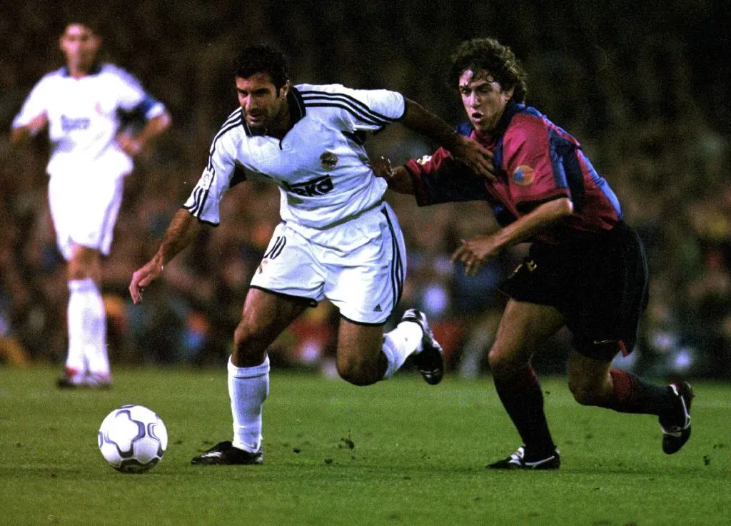 Luis Figo, do Real Madrid, se livra de Carles Puyol, do Barcelona, durante a partida da Primeira Divisão Espanhola entre Barcelona e Real Madrid no Camp Nou, em Barcelona, Espanha.