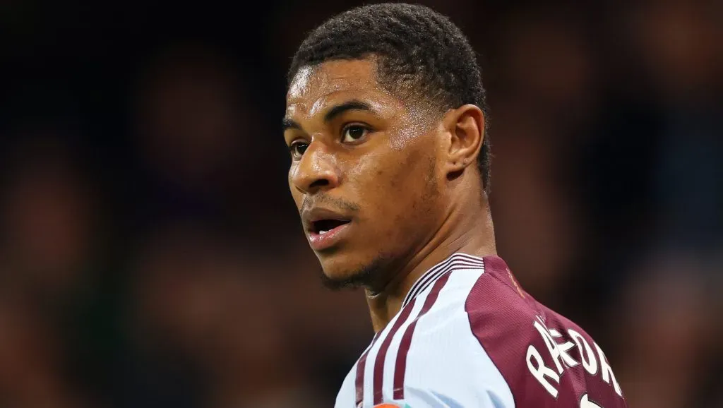 Rashford, em campo, com a camisa vinho e azul.