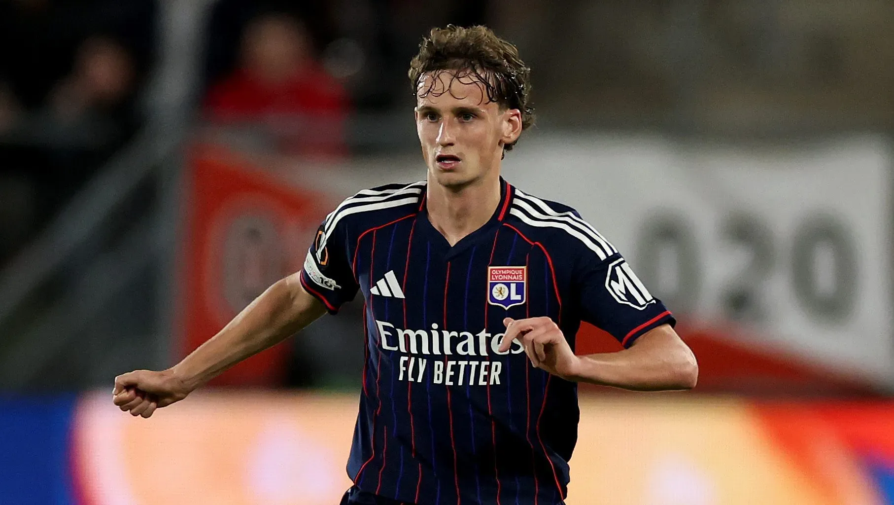 Tyler Morton, ex-Liverpool, em jogo do Lyon usando camisa azul marinho.